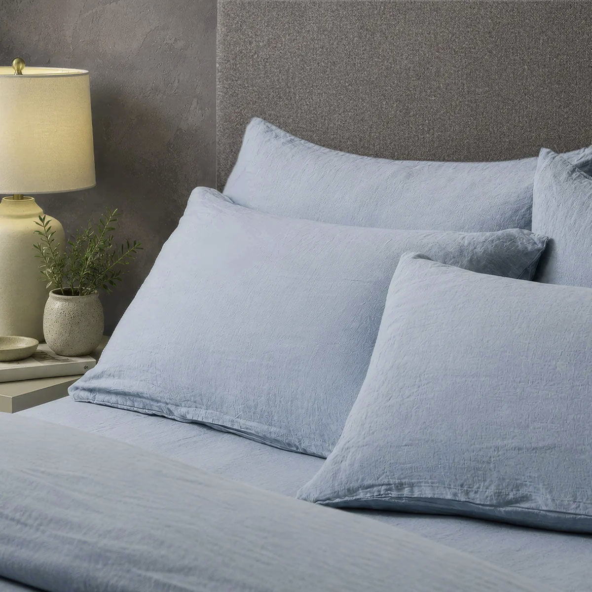 Four pillows on a dressed bed with the Mariana Linen Blend Pillow Cases in Cornflower.