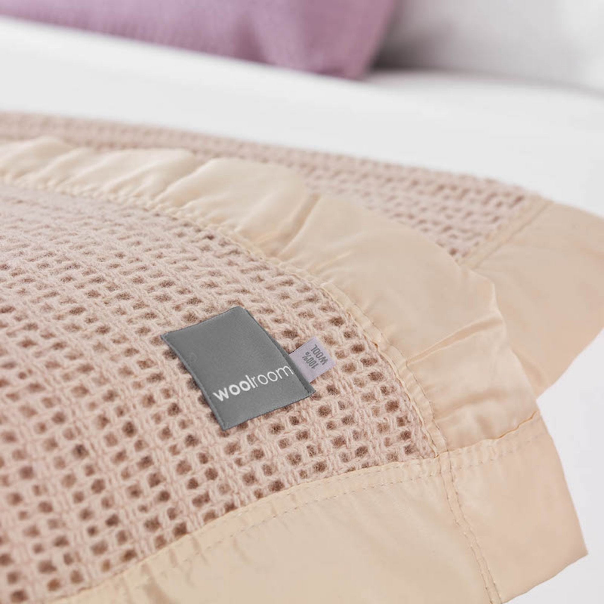 The Woolroom Ribblesdale Cellular Wool Bed Blanket in the color Mocha has a breathable open weave texture with a satin edge.