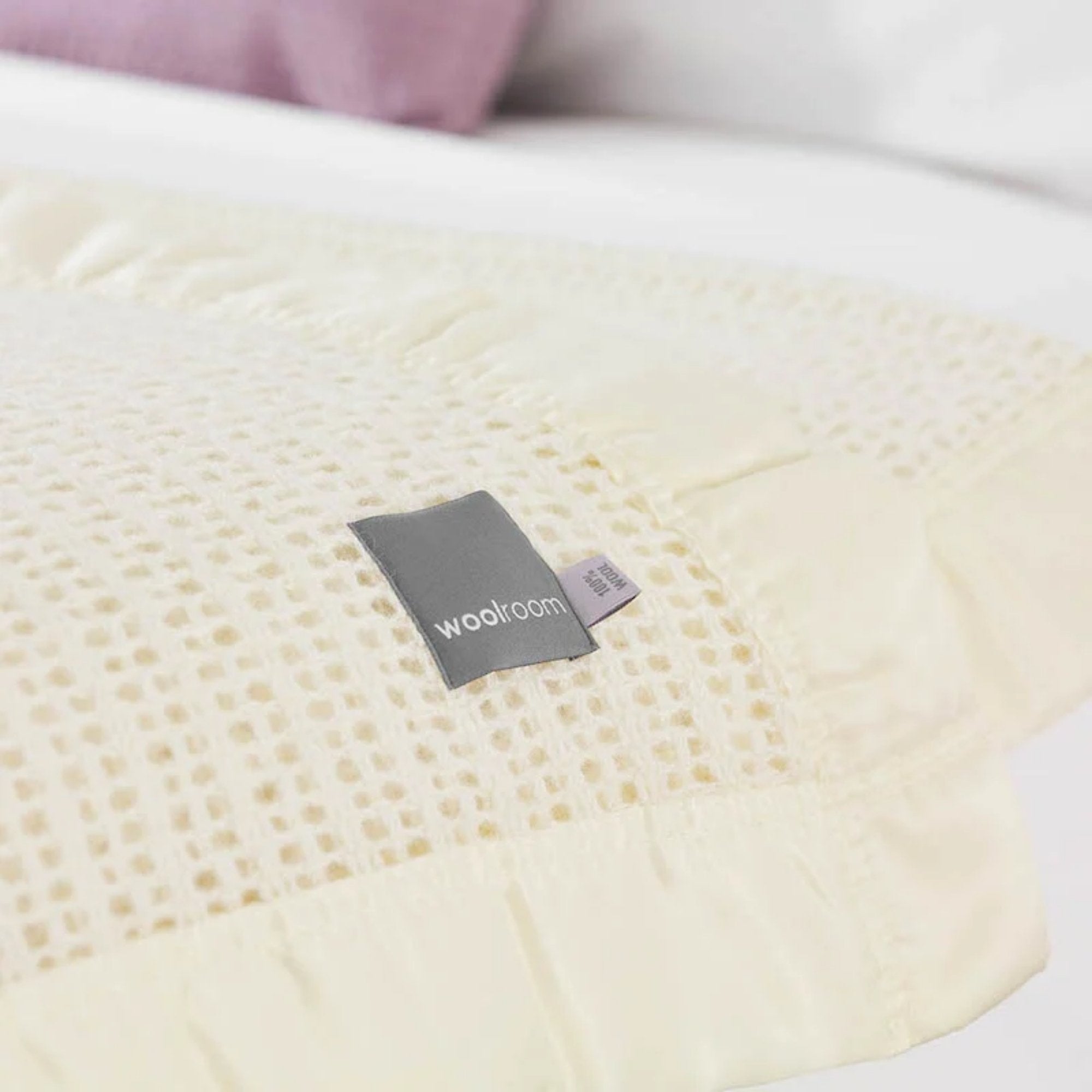 The Woolroom Ribblesdale Cellular Wool Bed Blanket in the color Pearl has a breathable open weave texture with a satin edge.