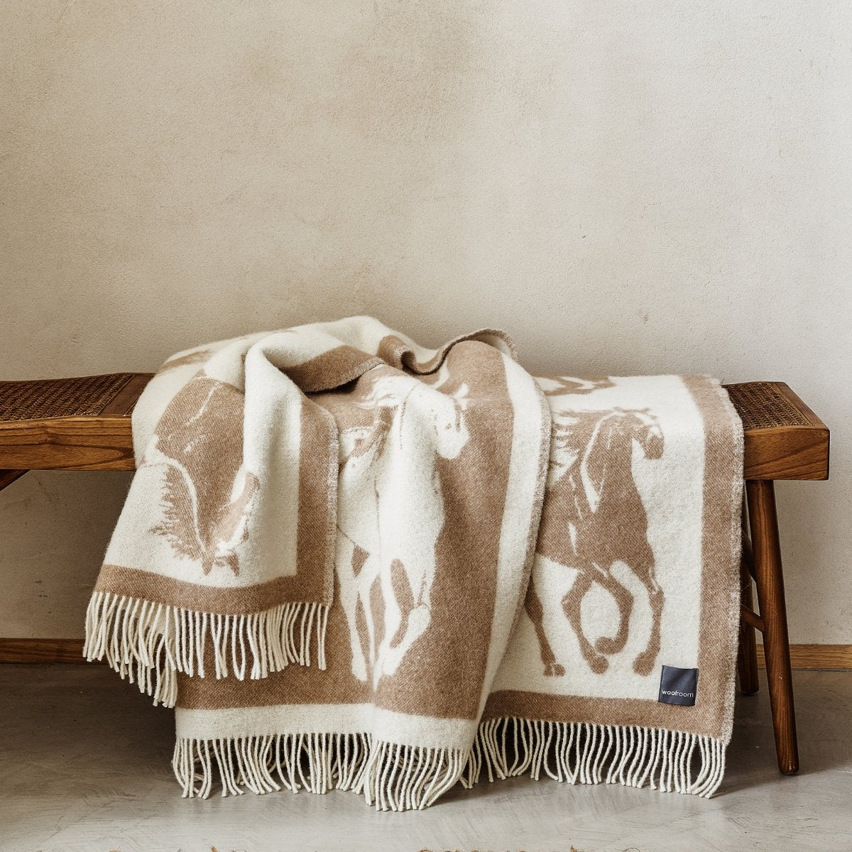 The playful Wild and Wool Horse Wool Throw in Latte with white fringe belongs to the Woolroom animal throw collection.