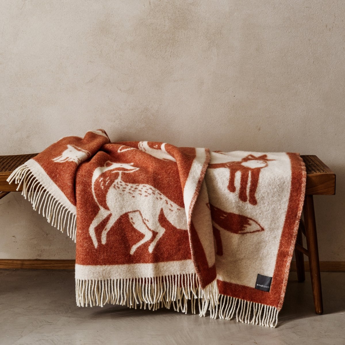 The playful Wild and Wool Fox Wool Throw in Rust with white fringe belongs to the Woolroom animal throw collection.