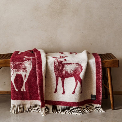 The playful Wild and Wool Deer Wool Throw in Berry with white fringe belongs to the Woolroom animal throw collection.