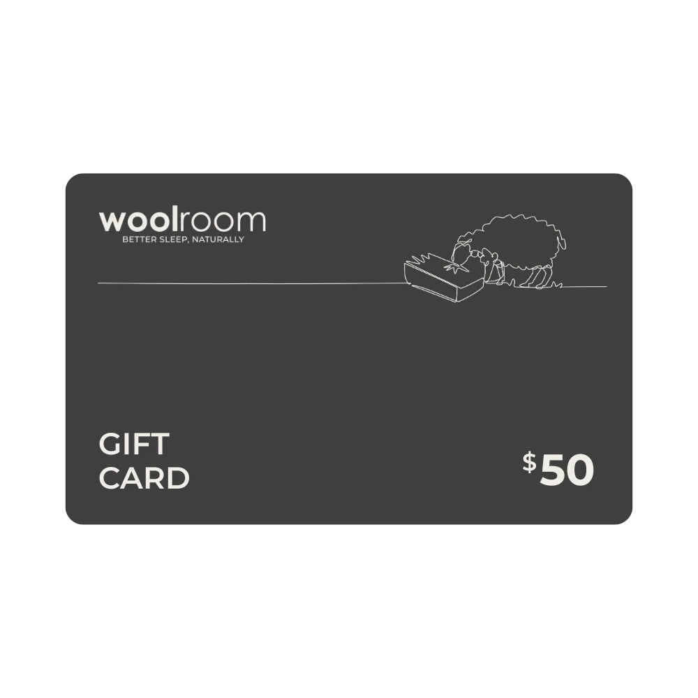 A 50 dollar Woolroom gift card on a solid white background. The card is dark gray with white text and a minimalist line drawing of a sheep.