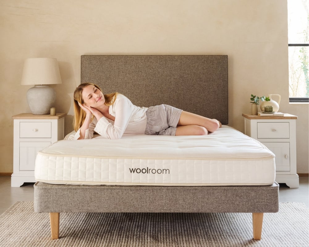 Woman lying on a woolroom mattress in a bedroom setting