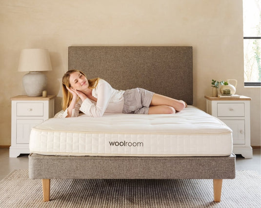 Woman lying on a woolroom mattress in a bedroom setting