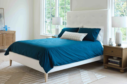 Grace upholstered bed with white tufted headboard and tapered wooden legs